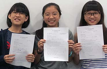 girls winning medals after attending math olympiad training in Singapore